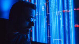 Man monitoring digital data screens, representing AI-driven IT services for SMBs